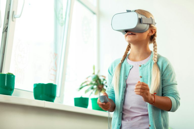 Impressed schoolgirl playing virtual games at school