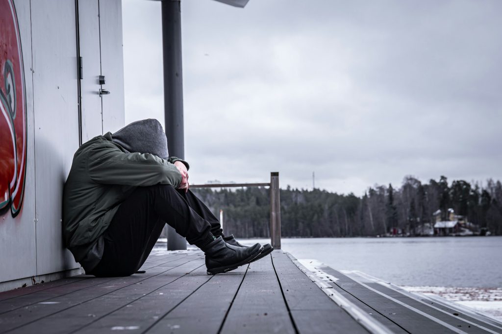 Lonely and sad man sitting on the ground